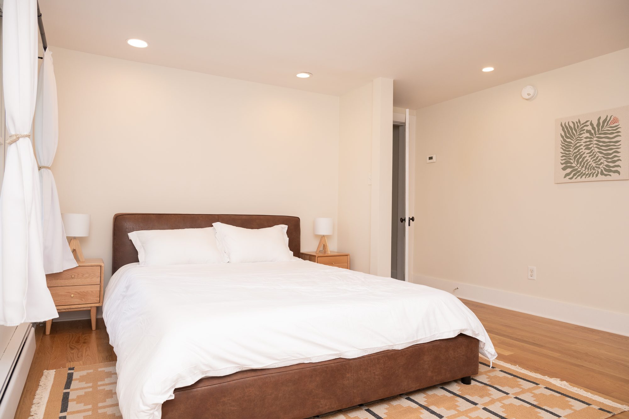 Queen bedroom with vaulted ceiling and white linens