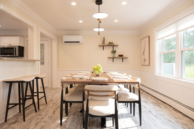 Dining table and two counter seats under pendant lights