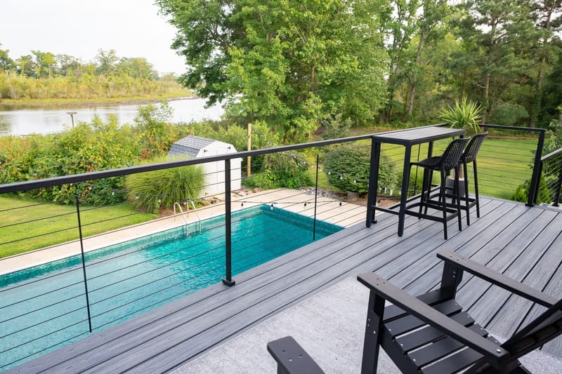 Pool deck with lounge chairs looking out to the water