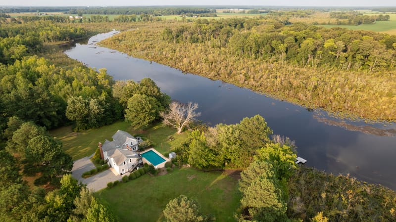 Aerial view of the farmhouse and pool beside the Little Blackwater River at golden hour